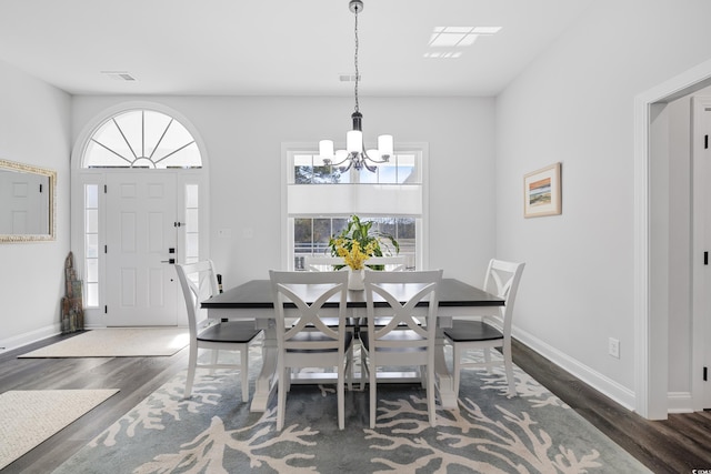 dining space featuring an inviting chandelier and dark hardwood / wood-style flooring