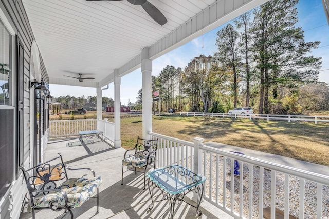 wooden terrace with a lawn, ceiling fan, and a porch