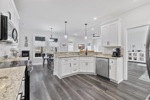 kitchen with white cabinetry, appliances with stainless steel finishes, decorative light fixtures, and kitchen peninsula