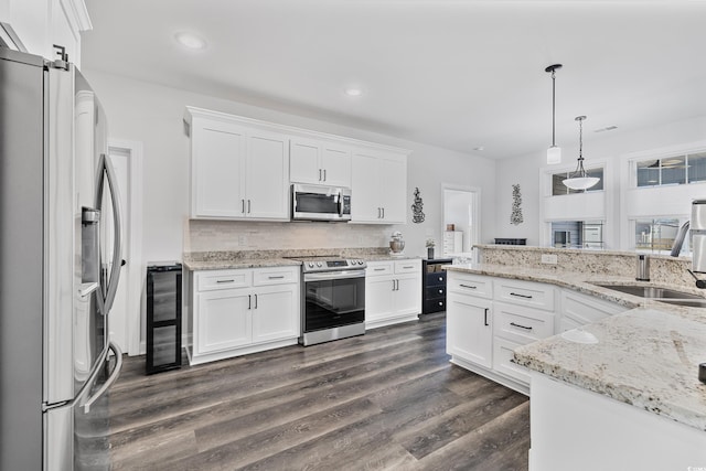 kitchen with appliances with stainless steel finishes, sink, and white cabinets