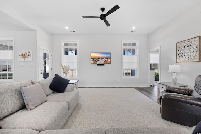 living room with wood-type flooring and ceiling fan