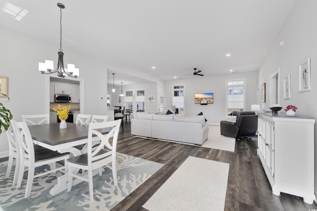 dining space with dark hardwood / wood-style floors and ceiling fan with notable chandelier