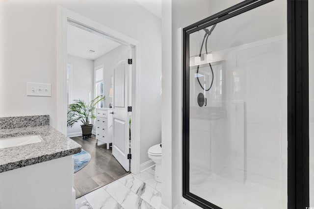 bathroom with vanity, toilet, and an enclosed shower