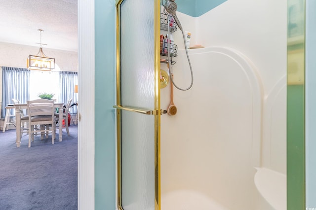 bathroom featuring a chandelier and a shower with shower door