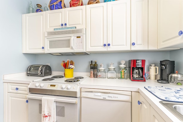 kitchen featuring white appliances, white cabinetry, and light countertops
