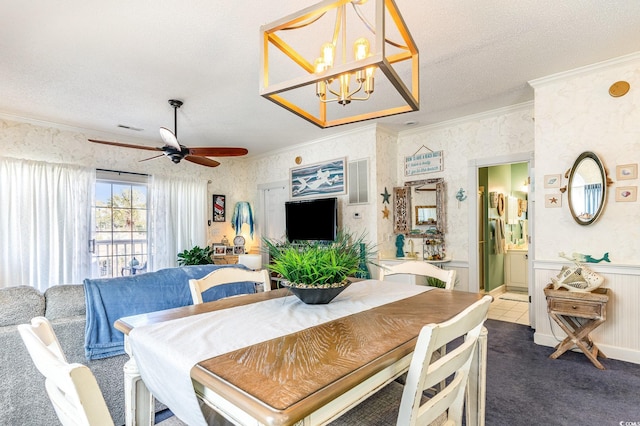 dining space featuring carpet floors, ornamental molding, ceiling fan with notable chandelier, and a textured ceiling