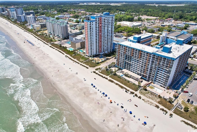 drone / aerial view featuring a water view, a beach view, and a city view