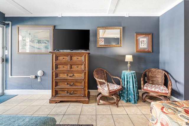 sitting room with light tile patterned floors, ornamental molding, and a textured ceiling