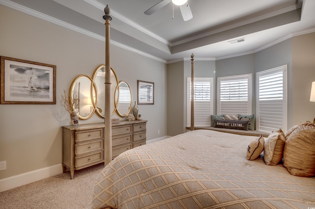 bedroom with crown molding, light colored carpet, ceiling fan, and a tray ceiling