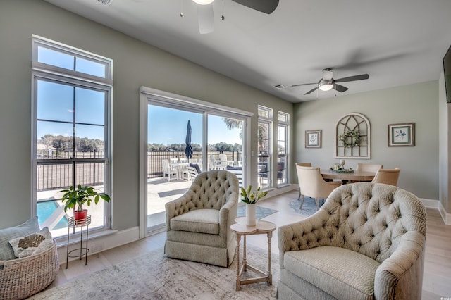 living room with ceiling fan and light hardwood / wood-style flooring