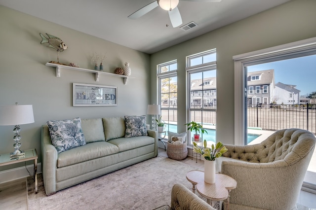 living room with ceiling fan and light hardwood / wood-style flooring