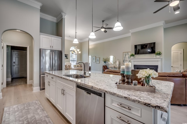 kitchen with stainless steel appliances, decorative light fixtures, sink, and white cabinets