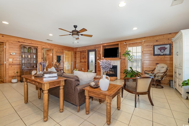 tiled living room featuring ceiling fan and wood walls