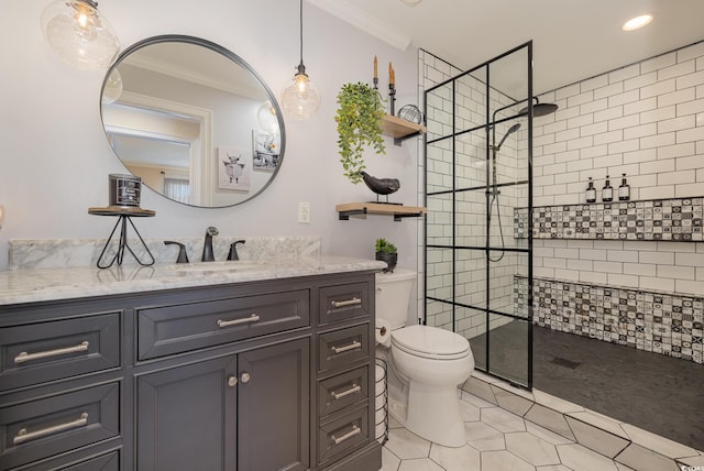 bathroom featuring a tile shower, tile patterned flooring, vanity, toilet, and crown molding