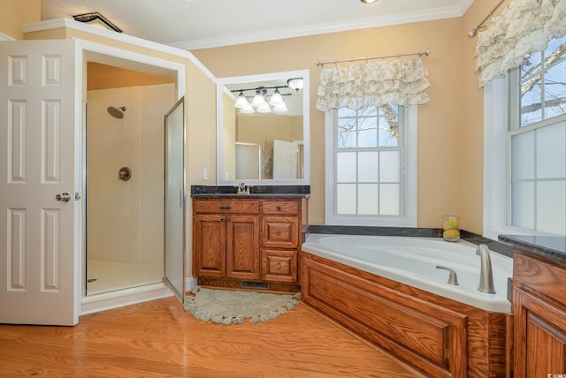 bathroom with ornamental molding, vanity, and shower with separate bathtub