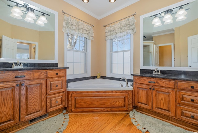 bathroom featuring hardwood / wood-style flooring, vanity, a tub, and crown molding