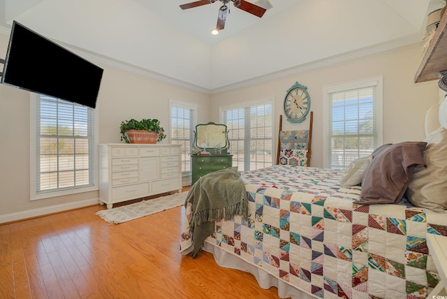 bedroom featuring ornamental molding, vaulted ceiling, multiple windows, and light wood-type flooring