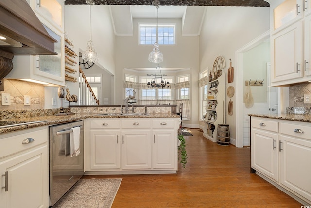 kitchen with decorative light fixtures, dishwasher, and white cabinets