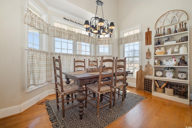 dining room featuring hardwood / wood-style flooring, ornamental molding, and a chandelier