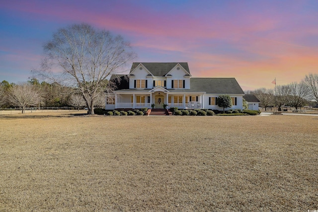 view of front of home featuring covered porch and a lawn