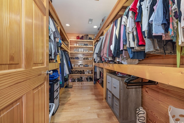 walk in closet with light hardwood / wood-style flooring