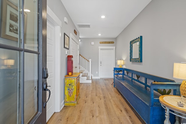 foyer entrance with recessed lighting, visible vents, baseboards, stairs, and light wood-style floors