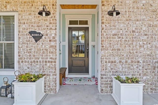 view of exterior entry featuring brick siding