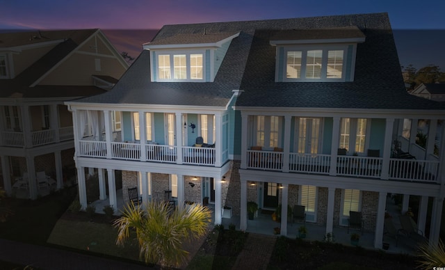 back of house featuring a patio area and roof with shingles