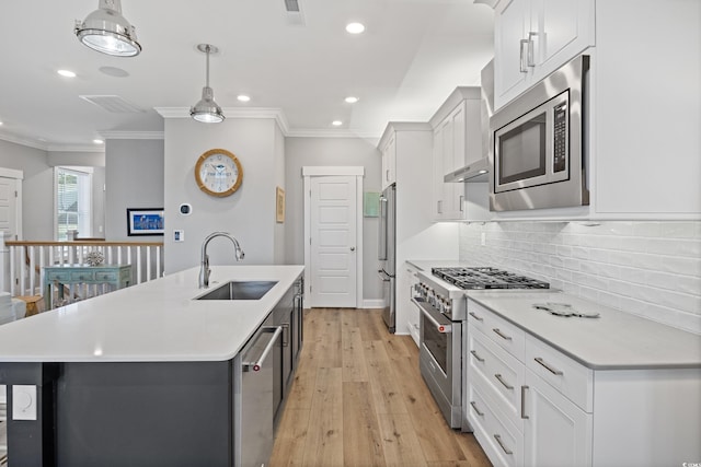 kitchen featuring light countertops, high end appliances, a sink, and a center island with sink