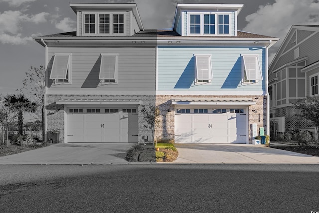 view of front of property featuring driveway, an attached garage, and brick siding