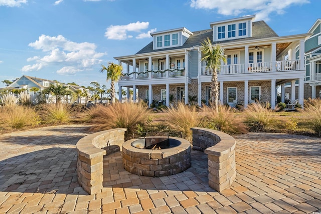 view of front of home featuring a fire pit, a ceiling fan, and a patio