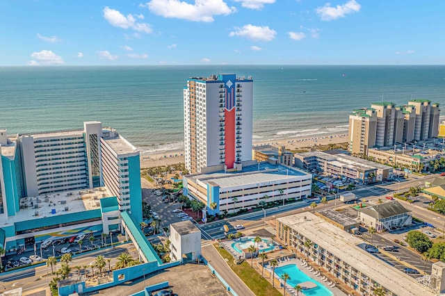 birds eye view of property with a water view and a beach view