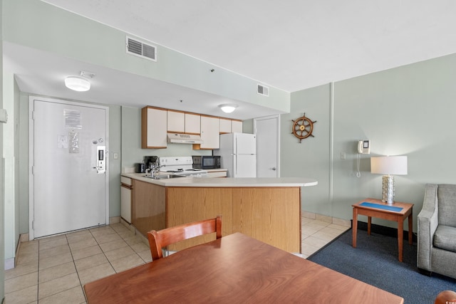 kitchen featuring sink, light tile patterned floors, white appliances, and kitchen peninsula