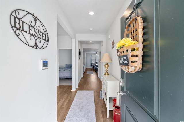 corridor with baseboards and wood finished floors