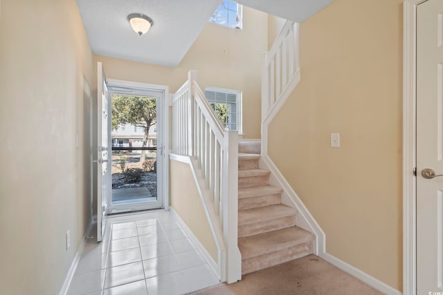 stairway with tile patterned flooring and a textured ceiling