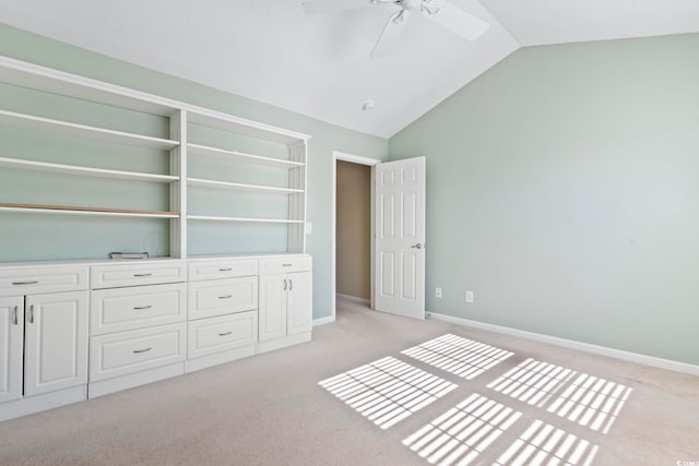 unfurnished bedroom with vaulted ceiling, light colored carpet, and ceiling fan