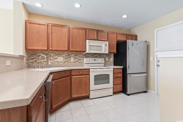 kitchen featuring sink, tasteful backsplash, a textured ceiling, light tile patterned floors, and white appliances