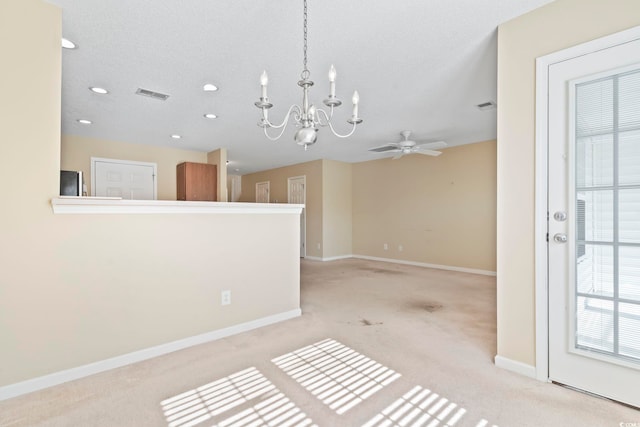 interior space with light colored carpet, ceiling fan with notable chandelier, and a textured ceiling