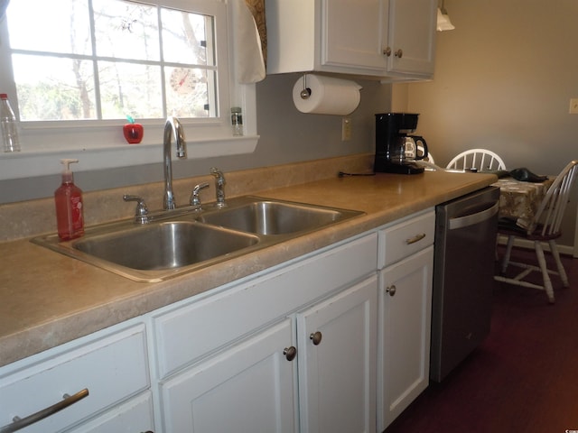 kitchen with dishwasher, white cabinetry, and sink