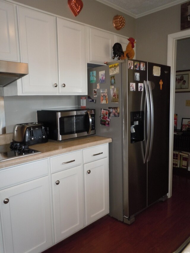 kitchen with stainless steel appliances, white cabinetry, dark wood-type flooring, and ornamental molding