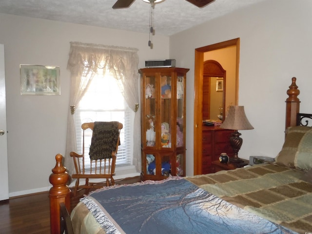 bedroom with multiple windows, dark wood-type flooring, and a textured ceiling