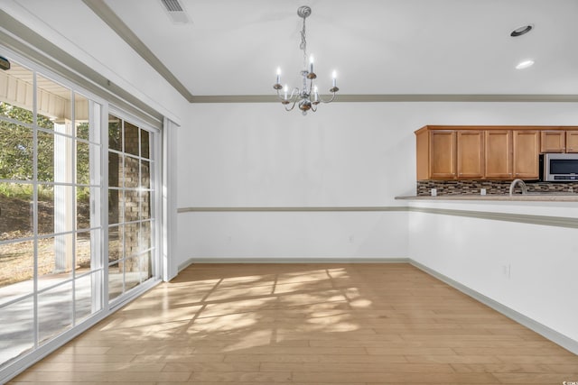 502 Hay Hill Ln Unit B, Myrtle Beach, SC 29579 - unfurnished dining area with ornamental molding, an inviting chandelier, and light hardwood / wood-style floors