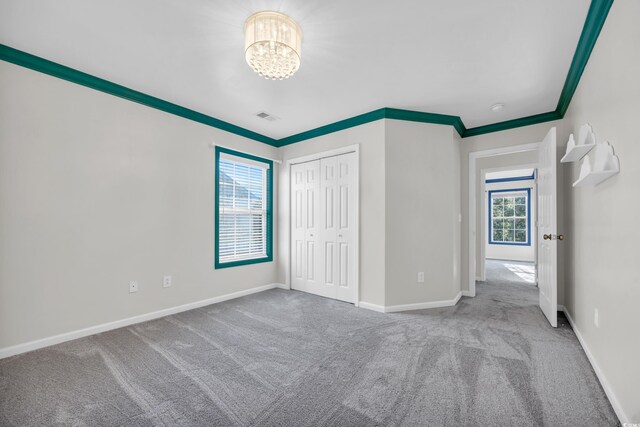 502 Hay Hill Ln Unit B, Myrtle Beach, SC 29579 - unfurnished bedroom with a closet, ornamental molding, carpet, and a notable chandelier