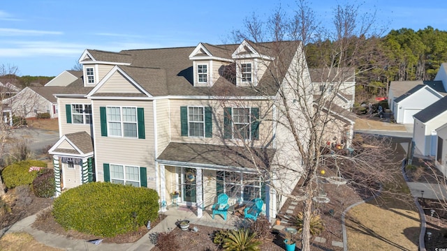 view of front of home with a patio and roof with shingles