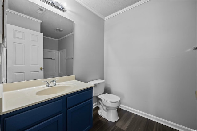 bathroom featuring a textured ceiling, wood-type flooring, ornamental molding, and toilet