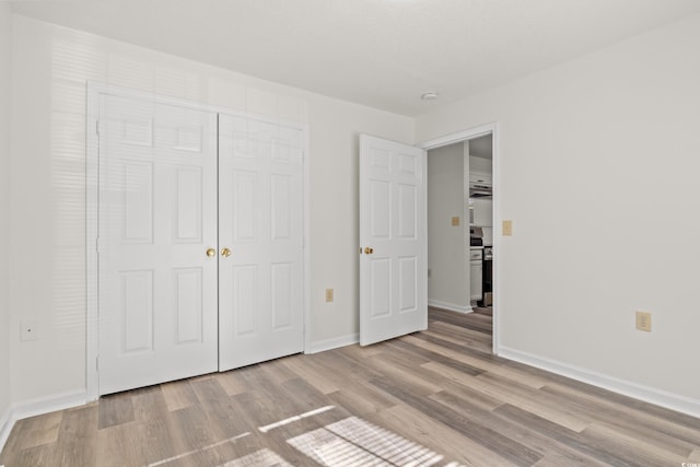 unfurnished bedroom with a closet and light hardwood / wood-style flooring