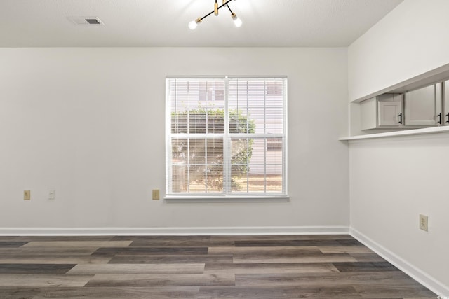 spare room featuring dark hardwood / wood-style flooring and a textured ceiling