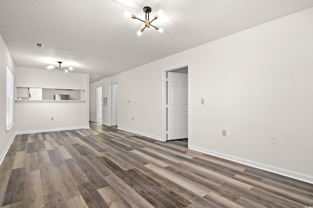 unfurnished living room with wood-type flooring, a chandelier, and a textured ceiling