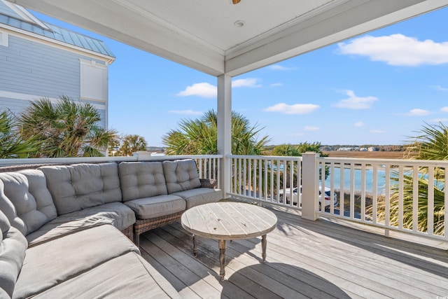 deck with a water view and outdoor lounge area