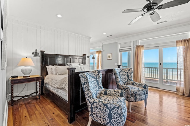 bedroom with crown molding, a water view, hardwood / wood-style floors, and access to exterior